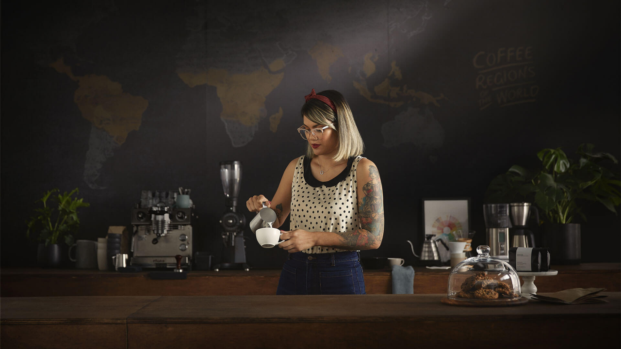 Une barista préparant un cappuccino.